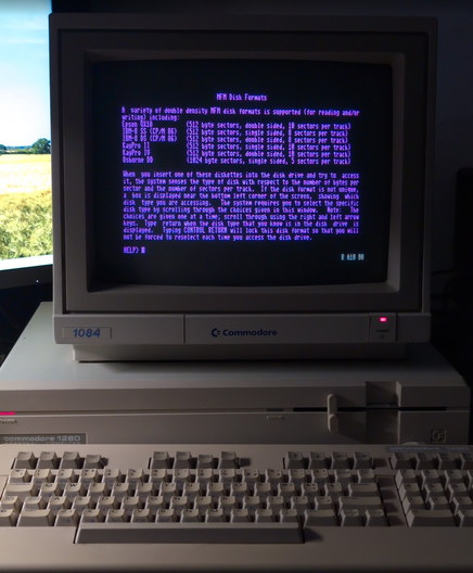 The same C128D, this time with its 1084 monitor in RGB TTL mode showing a CP/M 3.0 help page.
