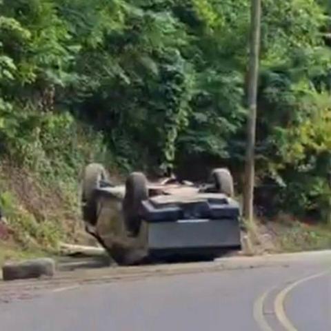 A crashed Cybertruck, upside down by the road
