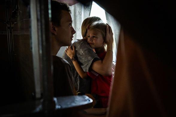 A child cries as they hug their mother prior to the departure of an evacuation train from Pokrovsk, Donetsk Oblast, Ukraine