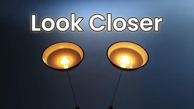 The image features a dark blue background with two illuminated light fixtures positioned symmetrically. Each fixture has a round, black outer rim and a warm, yellowish glow emanating from the exposed filament bulbs inside. The bulbs are encased in a shallow, concave bowl that reflects the light, enhancing the warm ambiance. Above the fixtures, the text "Look Closer" is prominently displayed in bold, white letters with a slight shadow effect, creating a sense of depth. The overall composition is simple yet striking, with the warm light contrasting against the cool blue background.

Provided by @altbot, generated privately and locally using Ovis2-8B