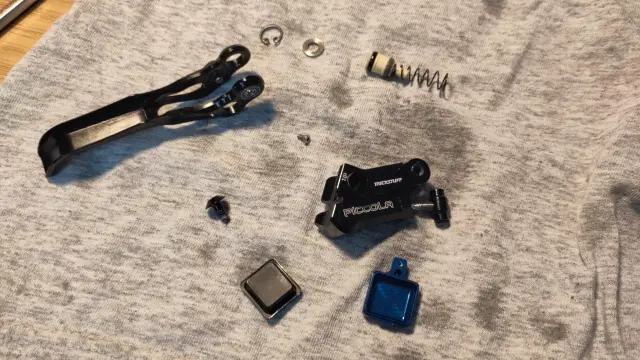 Auf einem Tuch liegen die Einzelteile einer zerlegten Bremspumpe der MTB Scheibenbremse Piccola von Trickstuff