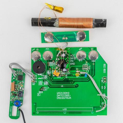 Oben: Ferrit-Antenne, darunter eine kleine Platine mit 2 Druckknöpfen, links eine kleine Platine mit einem IC, der Großteil des Bildes wird von der Hauptplatine