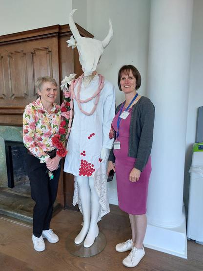 Two people and cow-headed sculpture