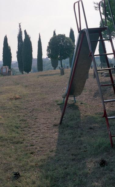 A playground slide against a background of trees