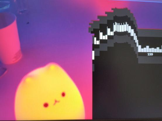 Photo of a screen showing an orange squishy cat robot which is actually part of the desktop background image. The cat is apparently staring intently at a terribly distorted EasyEffects window.