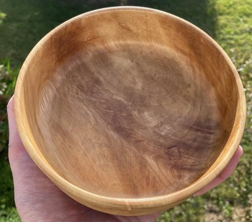 A golden brown bowl, with vertical sides, and dramatic grain.