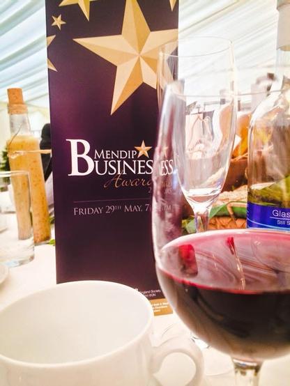 Banner for the Mendip Business Awards, with a cup and a glass of red wine in the foreground.