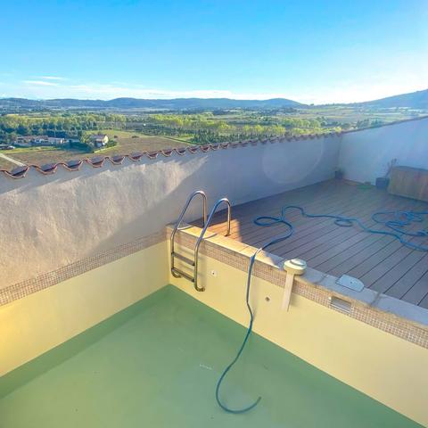 Rooftop pool filling up, with vineyards in the background.