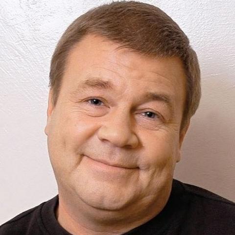 The photo of "Dukalis" - one of the main characters in the russian series about cops. The actor: Sergey Selin.
The photo depicts a man with a tilted head and a complicated and kind look to the camera.