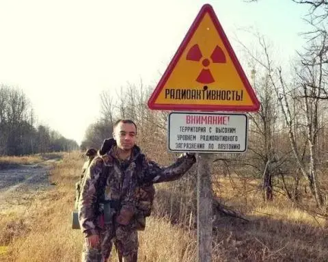 Ruslan Sidiki neben einem, Warnschild für eine nukleare militärische Sperrzone