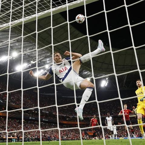 Tottenham Hotspur's Micky van de Ven clearing a headed shot off the goal line in mid air.