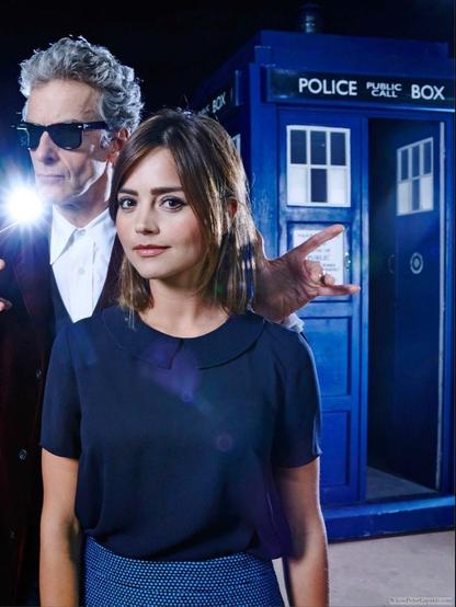 This is a photo of Peter Capaldi and Jenna Coleman standing next to each other, right beside a TARDIS.