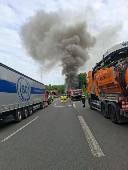 Die Feuerwehr löscht einen Reisebus, der in Flammen steht, auf der B236.