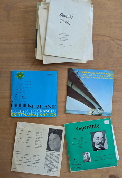 Four 7" records and a small pile of records and booklets, all in Esperanto. Kvar 7" vinildiskojn kaj malgranda stako da diskoj kaj libretoj, ĉiuj en Esperanto.