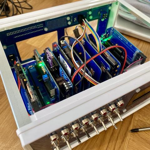 Computer with the lid removed. Inside are blue modular circuit boards and several wires connecting them here and there.