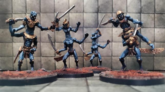 Four four armed blue skinned figures bearing swords and daggers