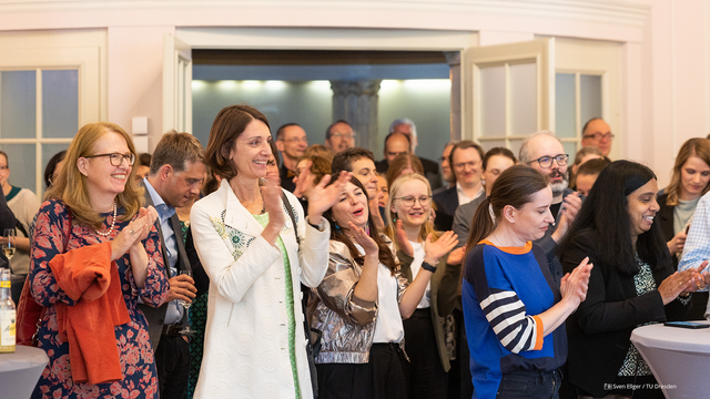 Foto von zahlreichen Personen, die die Die Entscheidung von DFG und Wissenschaftsrat gemeinsam mit den Mitgliedern des Erweiterten Rektorats der TUD im Festsaal des Rektoratsgebäudes mitverfolgten.