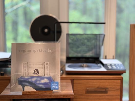 Regina Spektor - Far LP cover.

A drawing of Regina at her piano, in front of a window with bricks outside. Mostly monochrome except for the piano and her. The piano top is covered with clouds and blue sky.

The clear LP plays on a vintage, restored Bang & Olufsen Beogram 8002 linear-tracking turntable to the right.