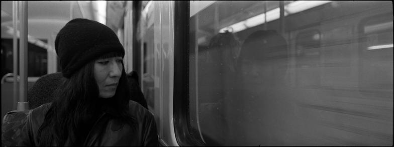 black and white portrait of a woman with a wistful look on a hamburg u-bahn train.