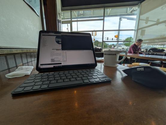 An iPad, keyboard, and mouse on a small table