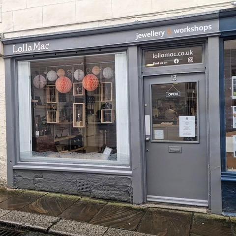 The LollaMac shop window, decorated for a different season with orange paper balls hanging in the window.