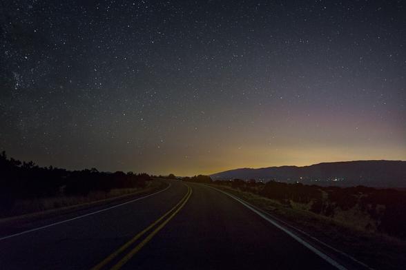 looking north on the Turquoise Trail just before dawn with the lights of Santa Fe visible in the distance below the Sangre de Christo Mountains.