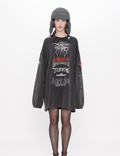 A model looking bored into the camera, she wears a weird hat and an oversized black long sleeve with a bunch of AI generated metal logo's that look very familiar.