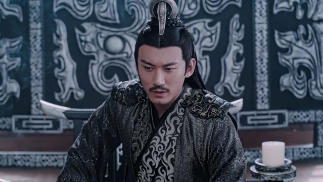 In a room in the Unclean Realm, Nie Mingjue sits, somewhat leaned forward with his body position indicating he is likely leaning on his left elbow, his right arm somewhat pulled back and positioned so that his right hand is resting palm down on perhaps a chair arm or nearby table. His expression gives the impression that he is mulling over some information.