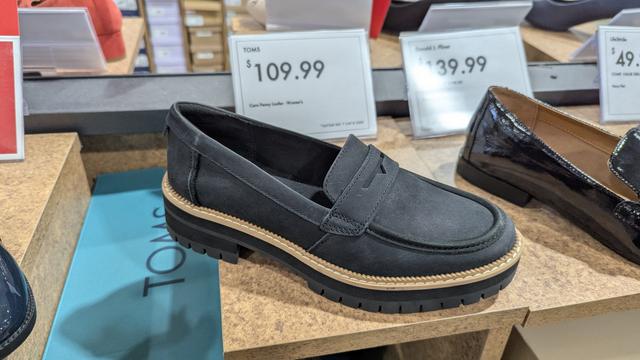 photo of a pair of grey leather Toms Cara Penny Loafers with a cream band sewn around the black sole 

retail price, $109.99