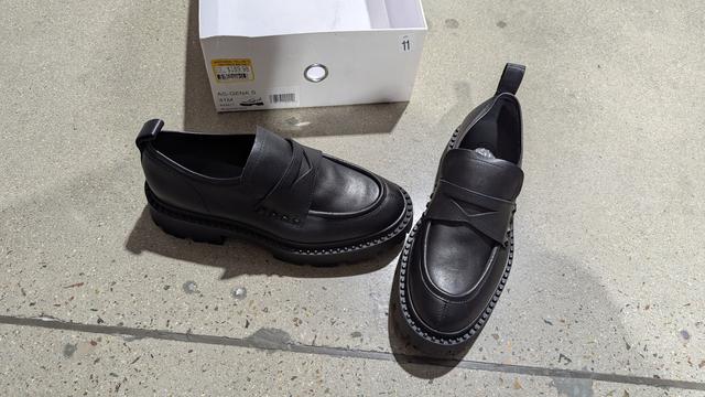 photo of a paper of all black leather penny loafers with a thick, meaty-ass tread, also in clearance