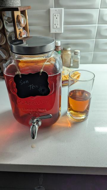 photo of Coleen's gallon tea jar, helpfully labeled, Sun Tea, and a glass, half full of tea