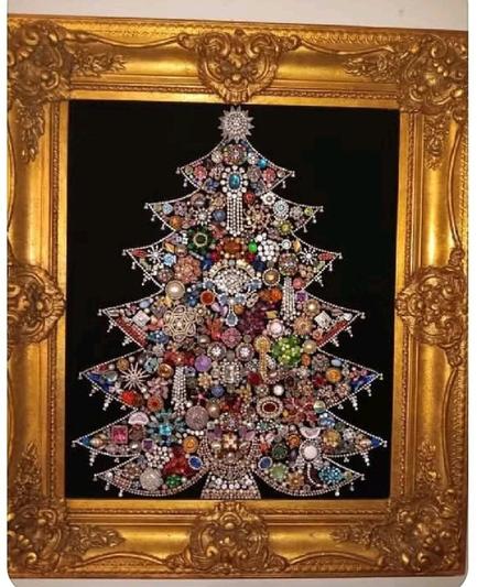 A home-crafted Christmas Tree image, made out of a large amount of various kinds of costume jewelry, pinned onto a black background and framed with a metallic gold square frame. Photo by Harper Lawson.