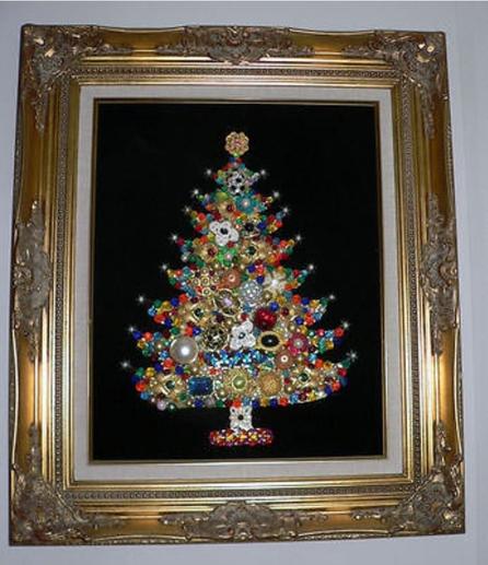 A different home-crafted Christmas Tree image, made out of a large amount of various kinds of costume jewelry, pinned onto a black background and framed with a metallic-painted square frame that is slightly brown and gold.