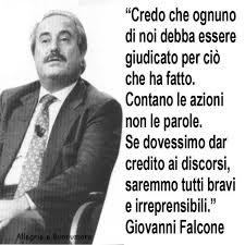 Foto di Giovanni Falcone seduto ed una sua citazione "credo che ognuno di noi debba essere giudicato per ciò che ha fatto. Contano le azioni non le parole. Se dovessimo dar credito ai discorsi, saremmo tutti bravi ed irreprensibili"