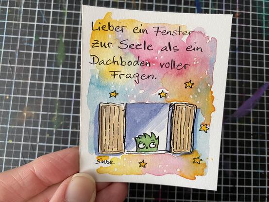 "Lieber ein Fenster zur Seele als ein Dachboden voller Fragen."
Ein gezeichnetes Fenster, aus dem ein Strüppi guckt. Rundherum bunte, verlaufene Aquarellfarben und Sterne.