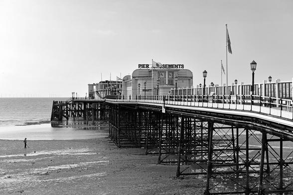 Monochrome photo of Worthing pier designed by Robert Rawlinson, 1862, Grade 2 listed. Fire damaged in 1933, the superstructure was remodelled in a Moderne style. Here viewed at low tide; the Rampion wind farm is just visible on the horizon. Worthing, West Sussex, UK.
Monochrome photo of Worthing pier designed by Robert Rawlinson, 1862, Grade 2 listed. Fire damaged in 1933, the superstructure was remodelled in a Moderne style. Here viewed at low tide; the Rampion wind farm is just visible on the horizon. Worthing, West Sussex, UK.