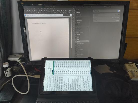 A Pinetab-V connected to an external monitor running libreoffice and htop.