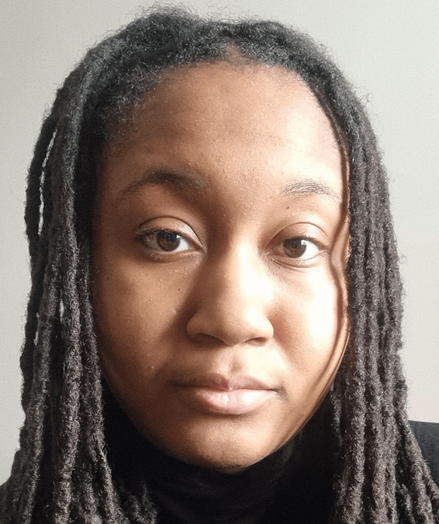 Headshot of a Black woman author with dreads, neutral expression looking into the camera, wearing a black top, against a plain wall background.