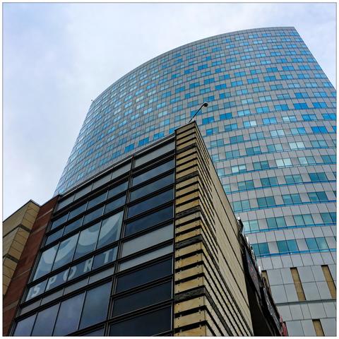 Upward tilt shot of a commercial building against a highrise.