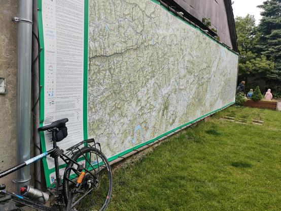 Big wall covered with map banner (~2x8m) and my bike in the corner.