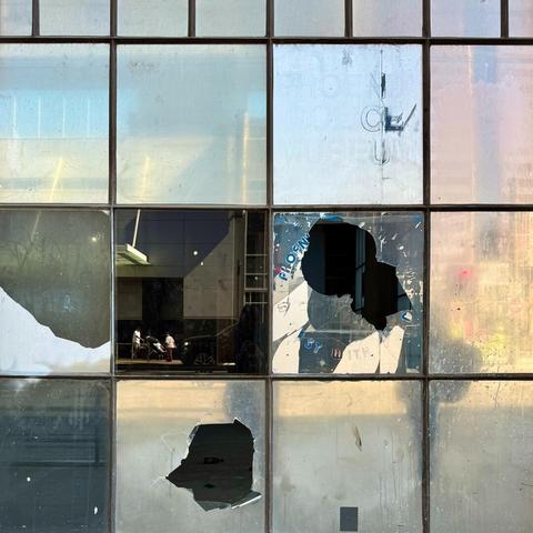 Window in a commercial space with a couple of panes that have been broken.