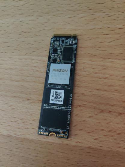 An M.2 SSD laying on a wooden desk.