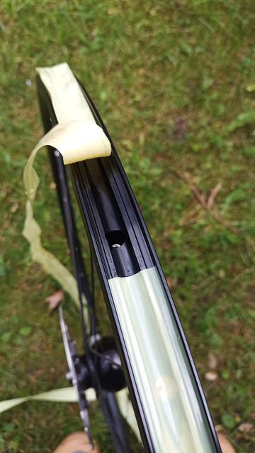 Eine Fahrradfelge wird von einem alten Felgenband befreit.