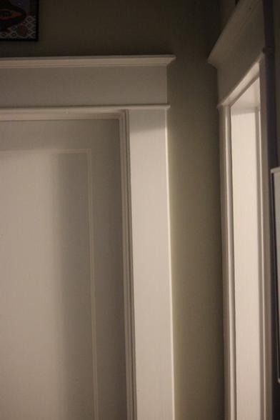 Two doorways at night. The open one is throwing light onto the closed one