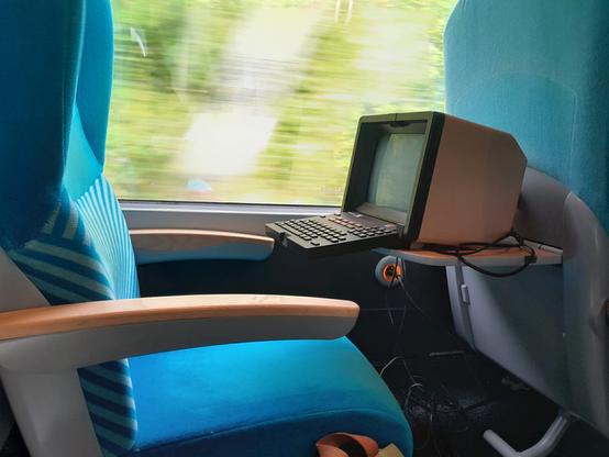 Photo d'un minitel sur une tablette de TER avec le paysage qui défile derrière