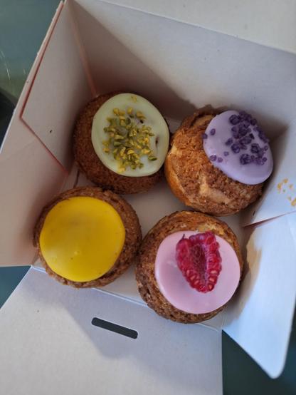 Ensemble de 4 choux à la crème de chez Yvonne avec un petit glaçage citron, framboise, violette et pistache