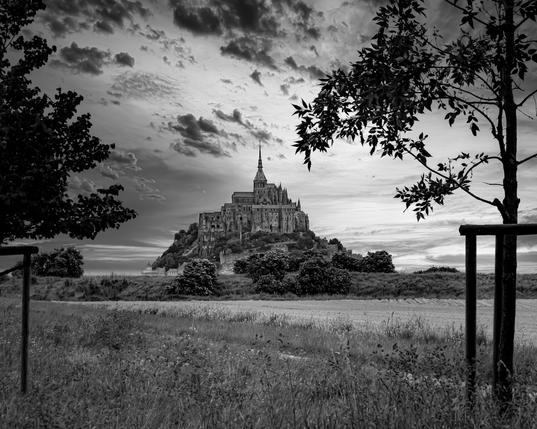 Mont-Saint-Michel von der Landseite her aufgenommen. Das Foto ist in Schwarzweiß.
