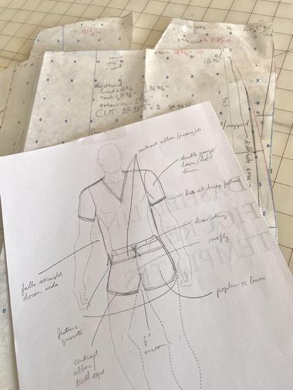 Sketch of a pair of drawstring short shorts and short sleeved tunic to lays atop pattern pieces for a pair of trousers.