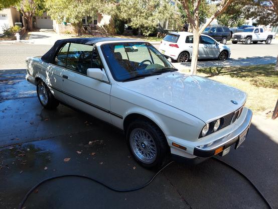 My Alpine White II 1990 E30 BMW convertible, with indigo interior and top and aftermarket (but period-correct) basketweave wheels. It's sitting in the driveway of our then-home in Vallejo California. I specifically sought out an E30 when I bought it in 2008, the last generation of tall, narrow BMWs that still reflected the neue klasse design language best reflected in the legendary 2002.  Over 13 years it got 3 new tops, 2 new interiors, and 30,000 miles of driving fun. Except for some minor bodywork, all the paint was still original.