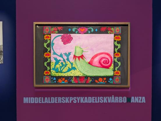 Close up picture of the middle section. There's a big pink stripe painted and a drawing of a snail with a neon pink shell looking up at a flowers. Around there's a border of multiple colorful flowers. Under the drawing is a long made-up word put up on the wall. It says "middelalderskpsykadelsikvårbonanza" which loosely translates to "dark age psychedelic spring bonanza"